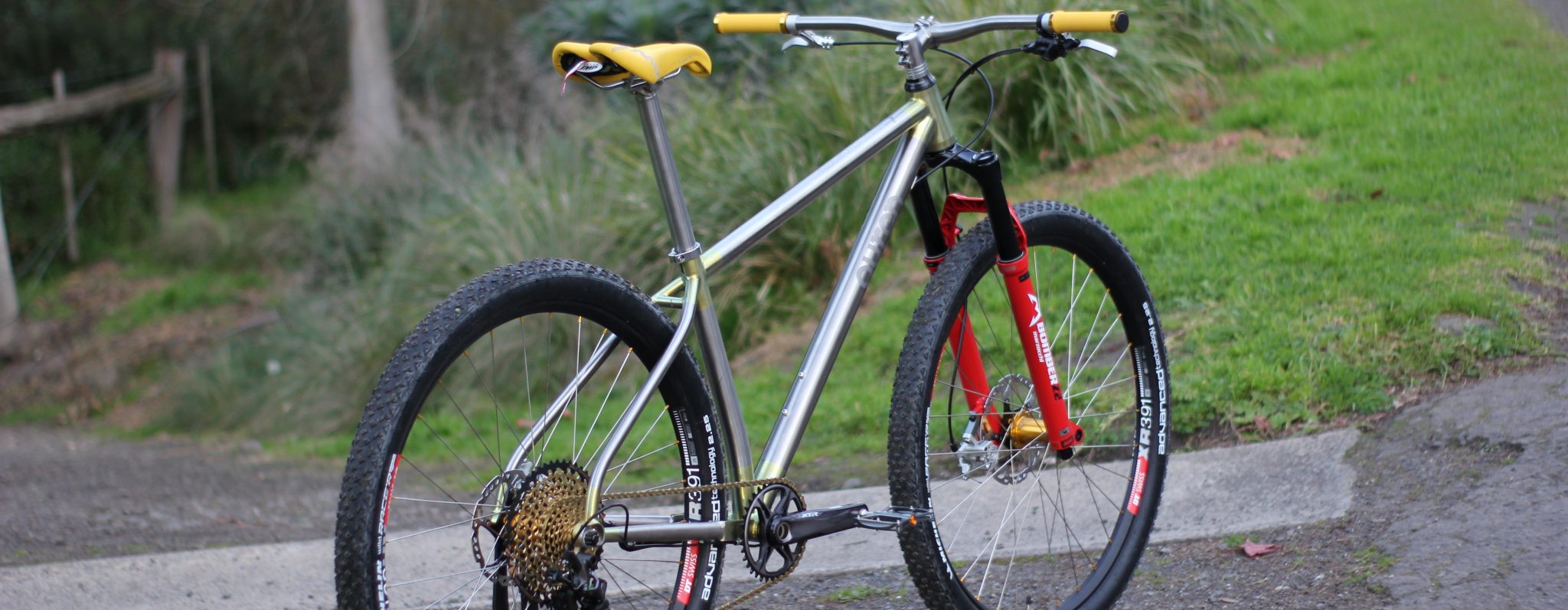 An Auren titanium hardtail on a grassy track