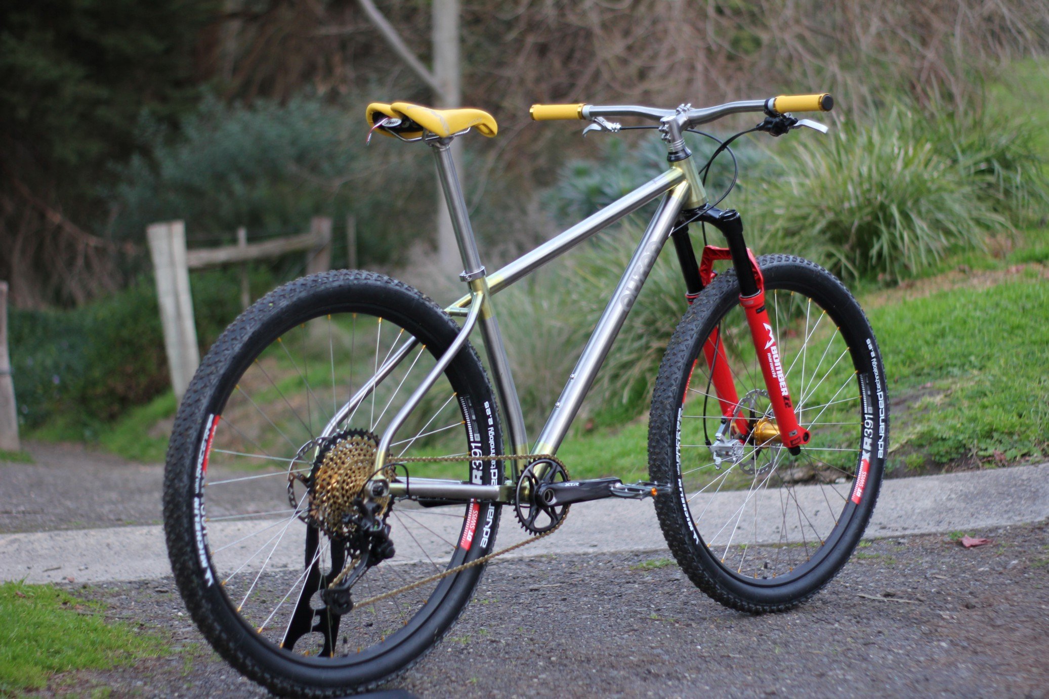 Auren titanium hardtail with a red fork and yellow saddle