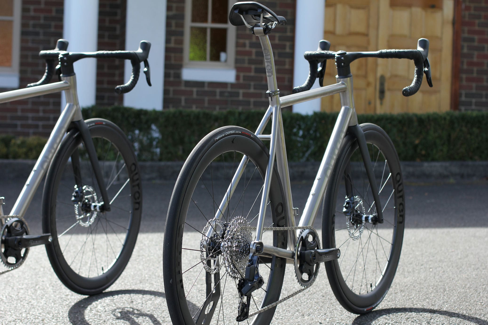 Two Auren titanium 1x road bikes, rear three-quarter view