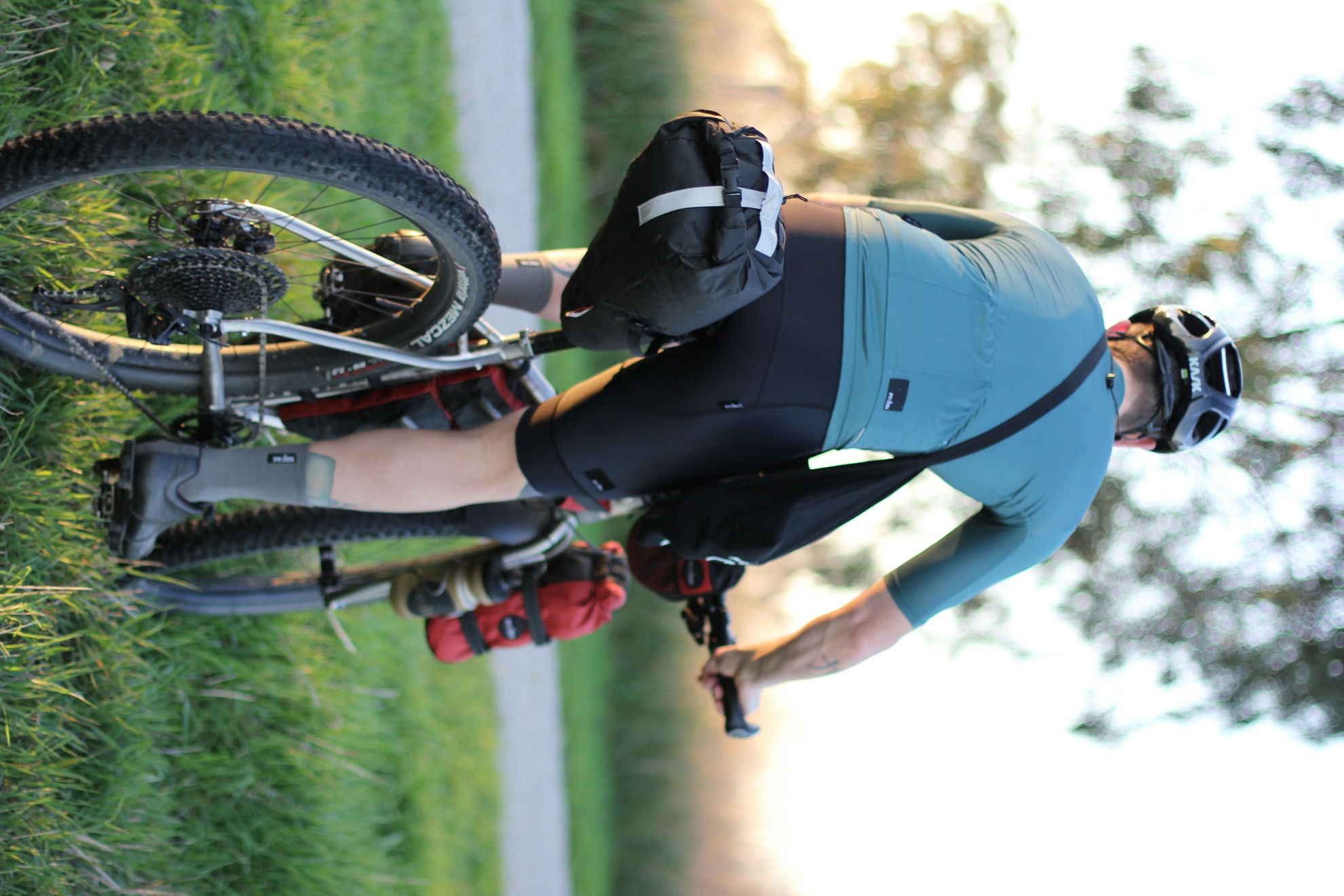 A rider on a loaded Auren titanium bike, seen from behind